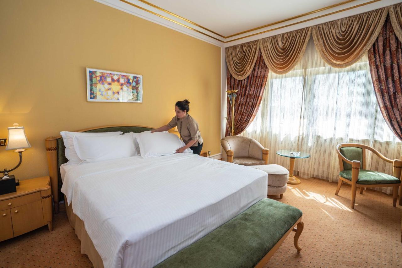 Officers Club & Hotel Abu Dhabi Eksteriør bilde A chambermaid making a bed in a hotel room